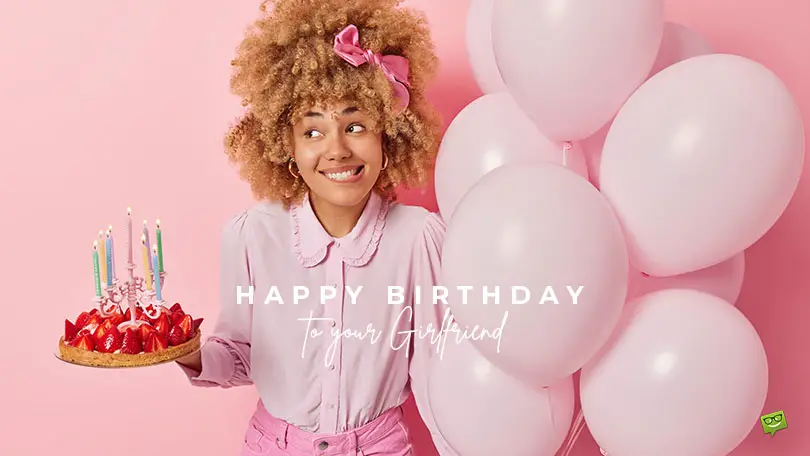 Featured image for a blog post with the best birthday wishes for girlfriend. The image features a fashionable young woman holding a birthday cake and pink balloons.