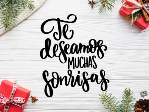 Imagen mimimalista para desear Feliz Navidad, con fondo blanco adornado con regalos y elementos decorativos navideños. Te deseamos muchas sonrisas.