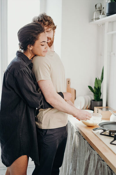 An image with a beautiful couple in the kitchen.